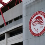 De ingang van het stadion van Olympiakos met het clubembleem op de gevel.