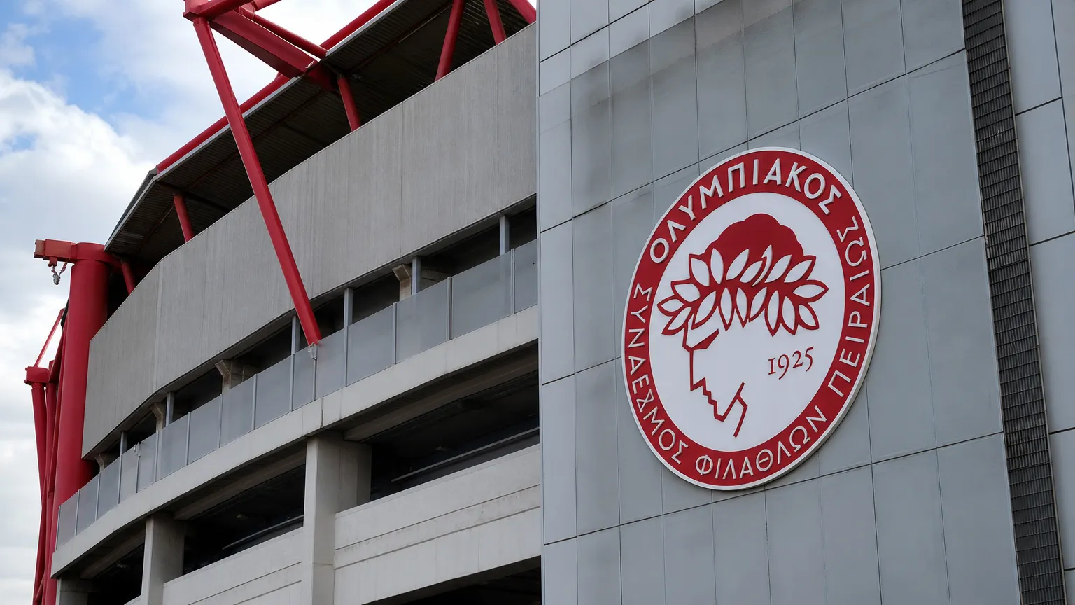 De ingang van het stadion van Olympiakos met het clubembleem op de gevel.