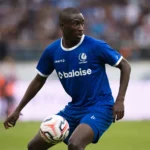 Mouhamed El Bachir Ngom in blauw wedstrijdtenue terwijl hij de bal op het veld controleert.