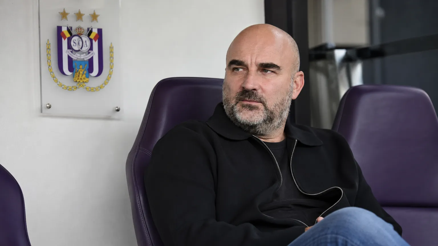 Antoine Sibierski zit in de technische zone van RSC Anderlecht tijdens een gesprek.