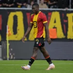 Adeshina Ayodele loopt in het rood-geel van KV Mechelen richting de zijlijn.