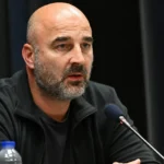 Antoine Sibierski spreekt tijdens een persmoment met microfoons voor zich.