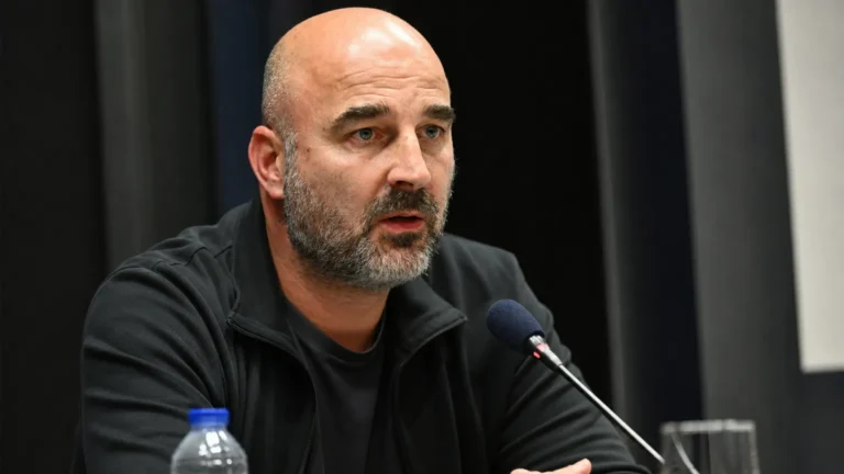 Antoine Sibierski spreekt tijdens een persmoment met microfoons voor zich.