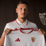 Lucas Stassin poseert met een FC Sevilla-shirt tijdens een officiële voorstelling.