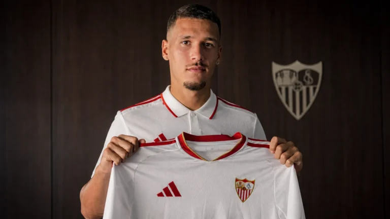 Lucas Stassin poseert met een FC Sevilla-shirt tijdens een officiële voorstelling.