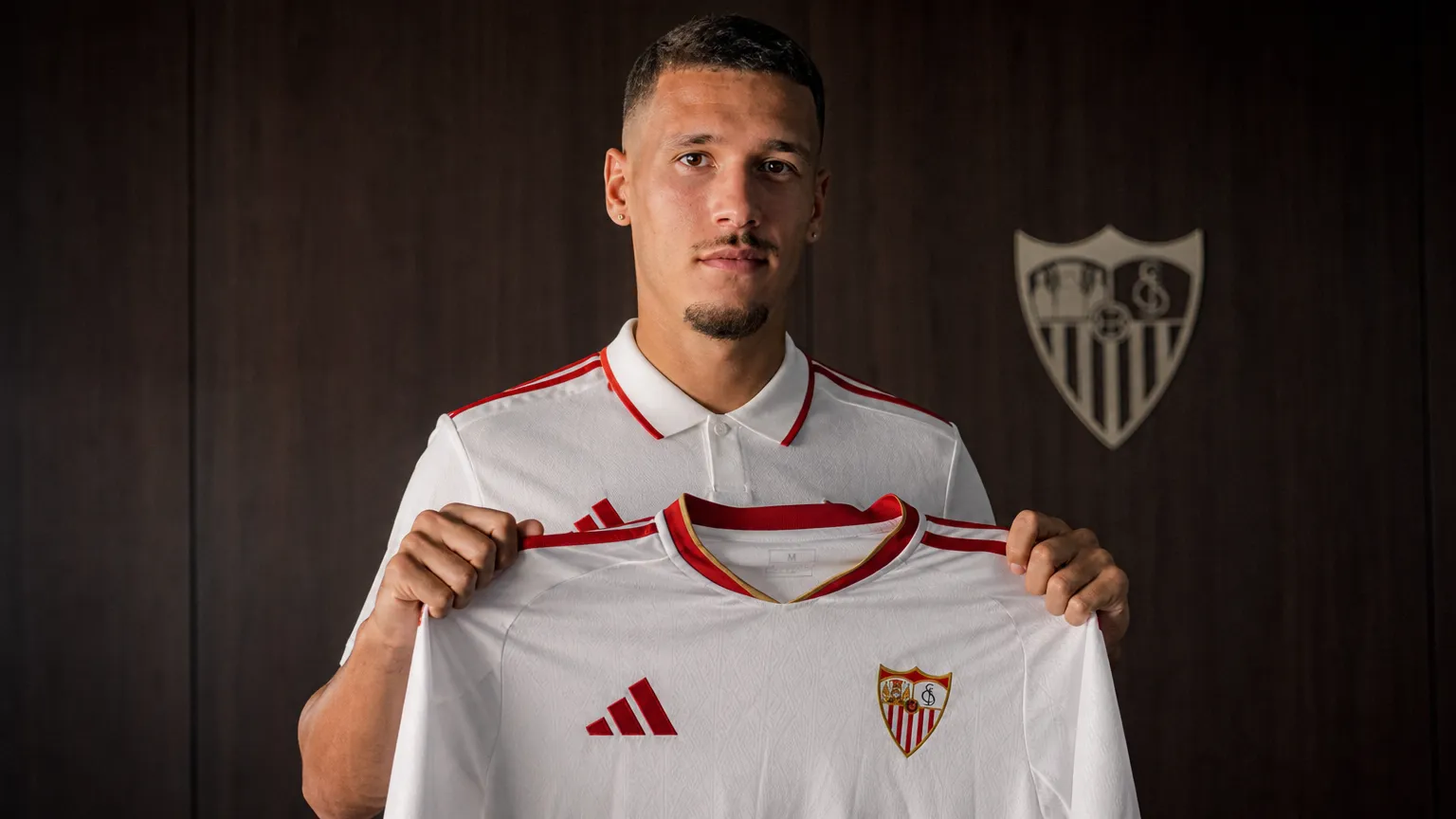 Lucas Stassin poseert met een FC Sevilla-shirt tijdens een officiële voorstelling.