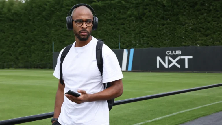 Denis Odoi in witte vrijetijdskleding bij een Club NXT-trainingscomplex.
