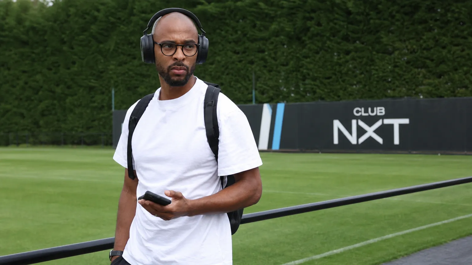 Denis Odoi in witte vrijetijdskleding bij een Club NXT-trainingscomplex.