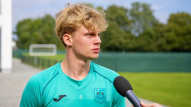 Cedric Hatenboer in een turquoise trainingstop tijdens een interview in openlucht.