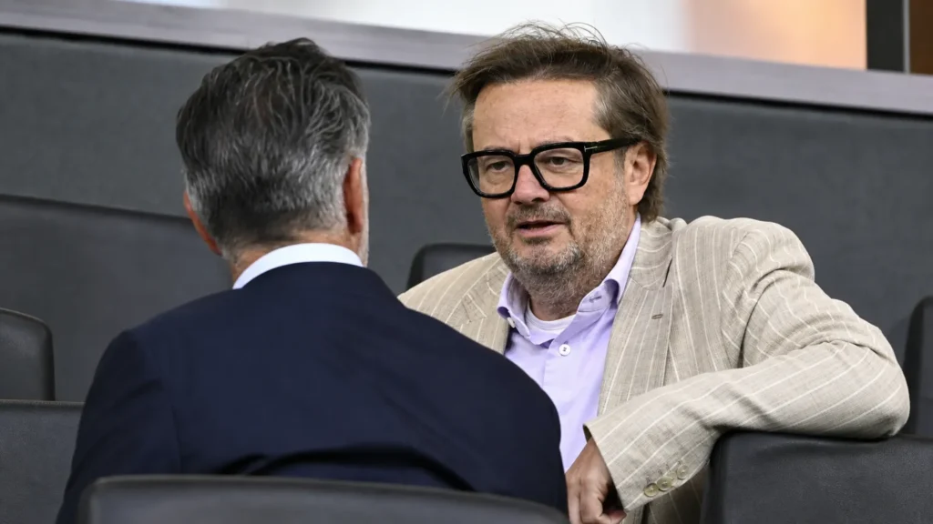 rsc-anderlecht-proces-verkoop-coucke-sven-mary Twee niet-spelende clubfiguren in gesprek in een indoor tribunezone.