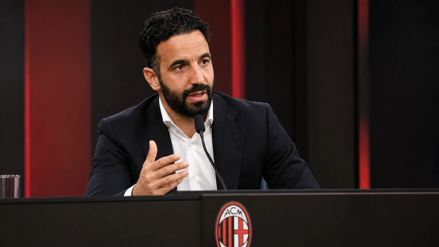 Rúben Amorim spreekt op een persconferentie van AC Milan achter een podium.
