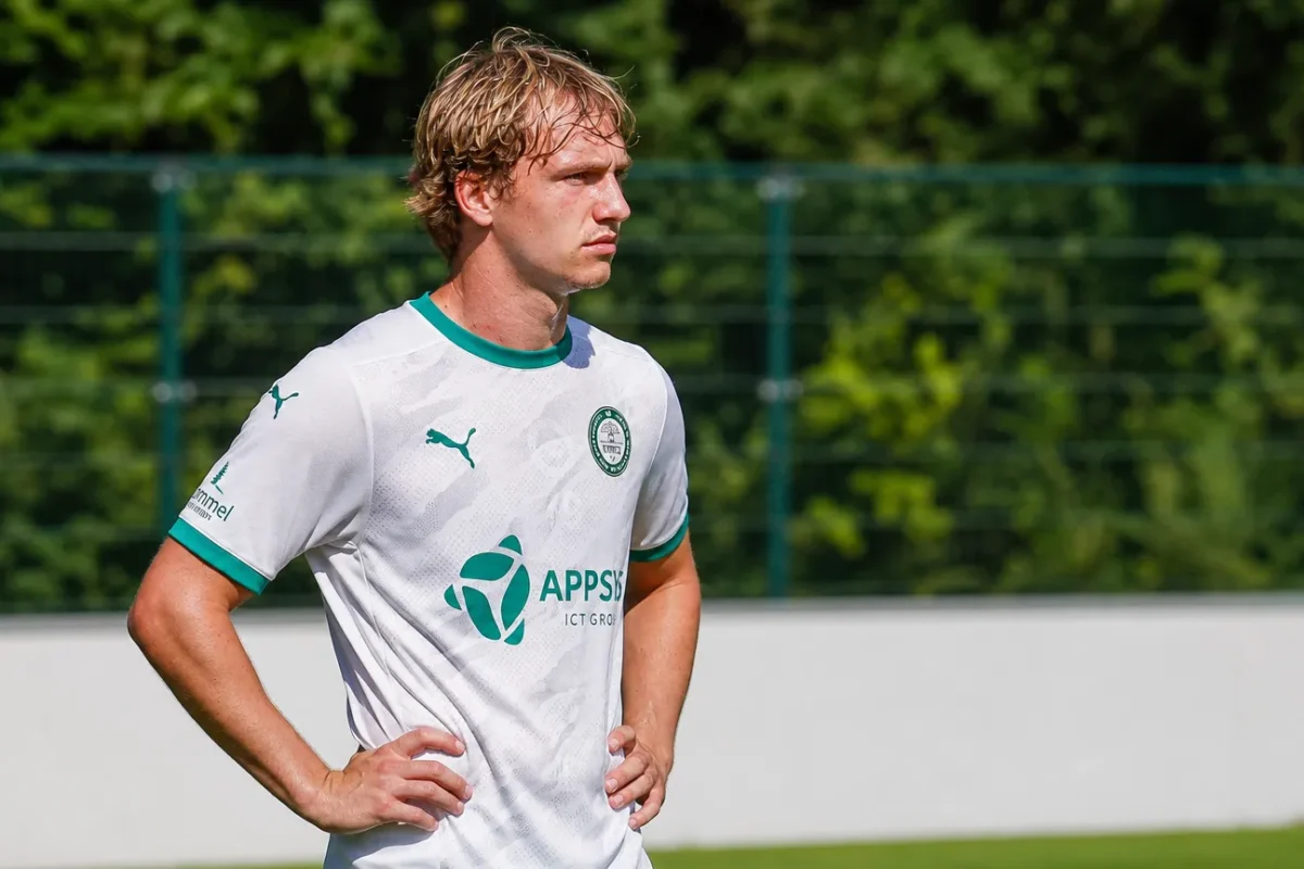Sam de Grand staat in het witte tenue van Lommel aan de rand van een oefenveld.