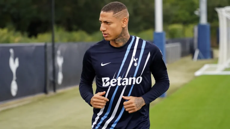 Richarlison warmt op in een donker Tottenham-tenue aan de rand van het trainingsveld.