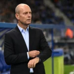 Jess Thorup staat geconcentreerd langs de zijlijn van KRC Genk voor een wedstrijd.