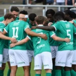 Een groep spelers van Lommel SK vormt een huddle naast het veld.