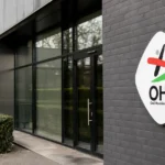 Lege ingang van een OH Leuven-clubgebouw met een vast clubembleem aan de gevel.