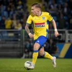 Een Westerlo-speler in geel-blauw tenue in actie tijdens een wedstrijd.