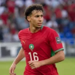 Anass Salah-Eddine in het tenue van Marokko langs de zijlijn van een stadion.
