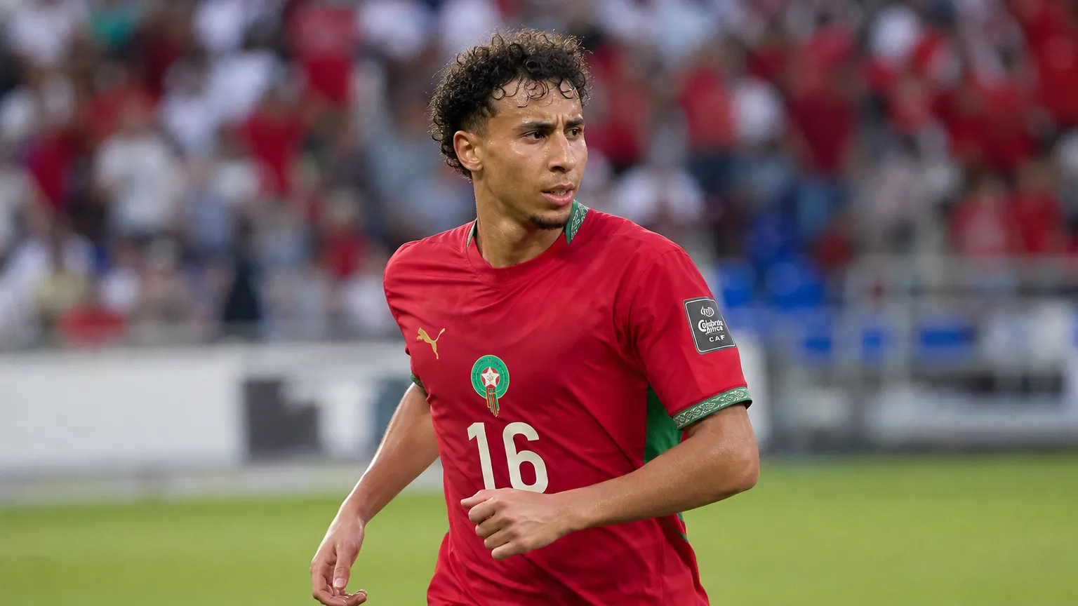 Anass Salah-Eddine in het tenue van Marokko langs de zijlijn van een stadion.