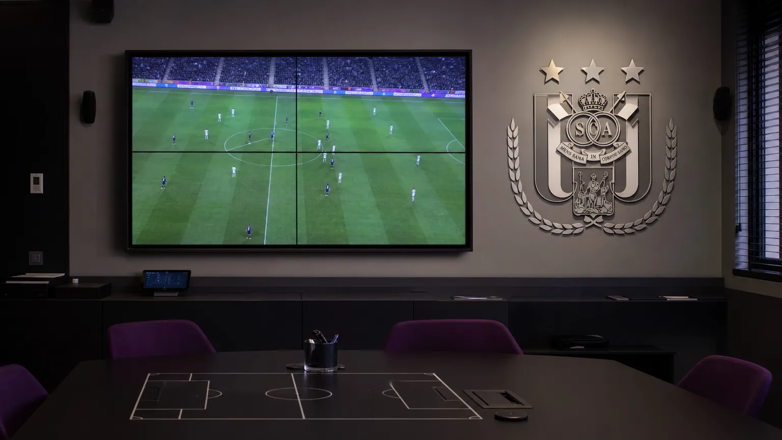 Lege analysekamer van RSC Anderlecht met een tactisch videoscherm en een clubembleem aan de muur.