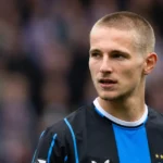 Romeo Vermant met zijn korte kapsel op het voetbalveld in donkerblauwe clubkleding.