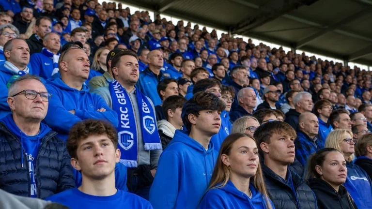Collectieve KRC Genk-supporters met blauw-witte sjaals in de Cegeka Arena voor de aftrap.