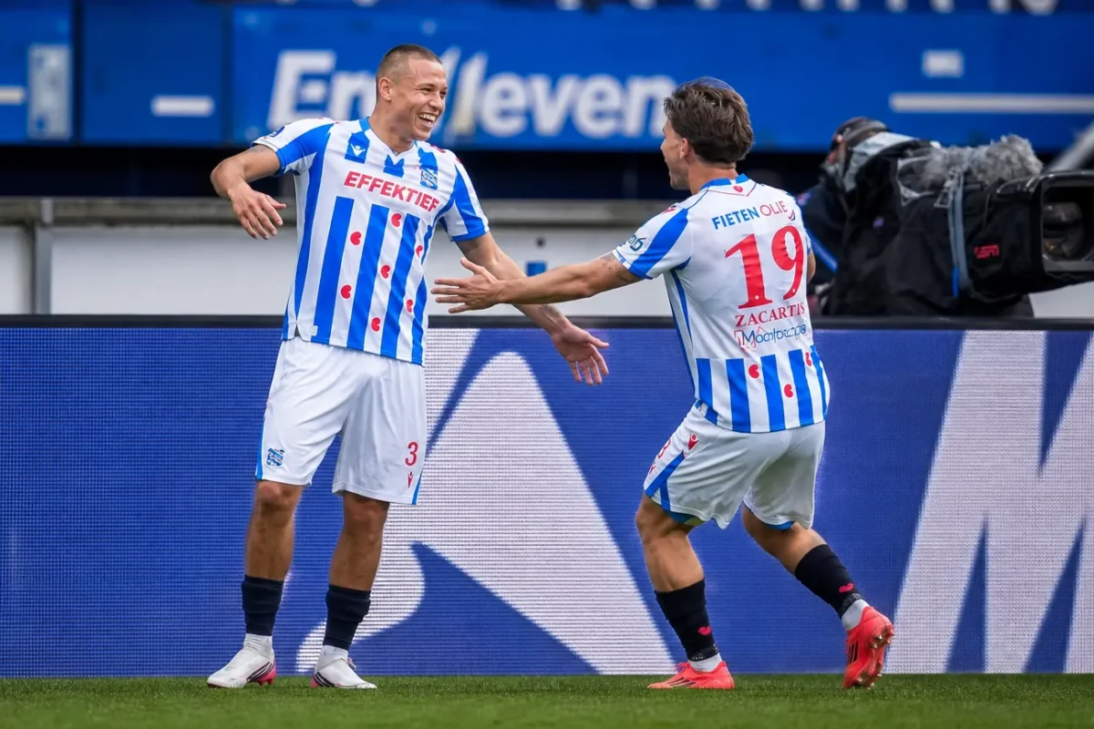 Twee spelers van sc Heerenveen vieren samen een moment langs het veld.