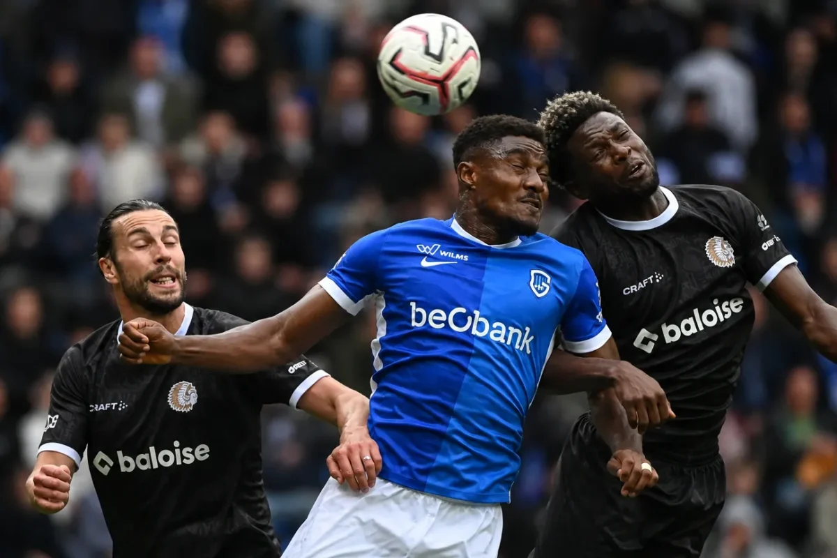 Spelers van KRC Genk en KAA Gent in een luchtduel tijdens de wedstrijd.