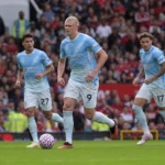 Manchester City-spelers in lichtblauwe tenues tijdens een nieuw wedstrijdmoment op Old Trafford.