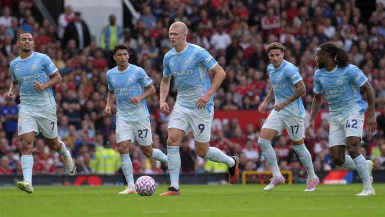 Manchester City-spelers in lichtblauwe tenues tijdens een nieuw wedstrijdmoment op Old Trafford.