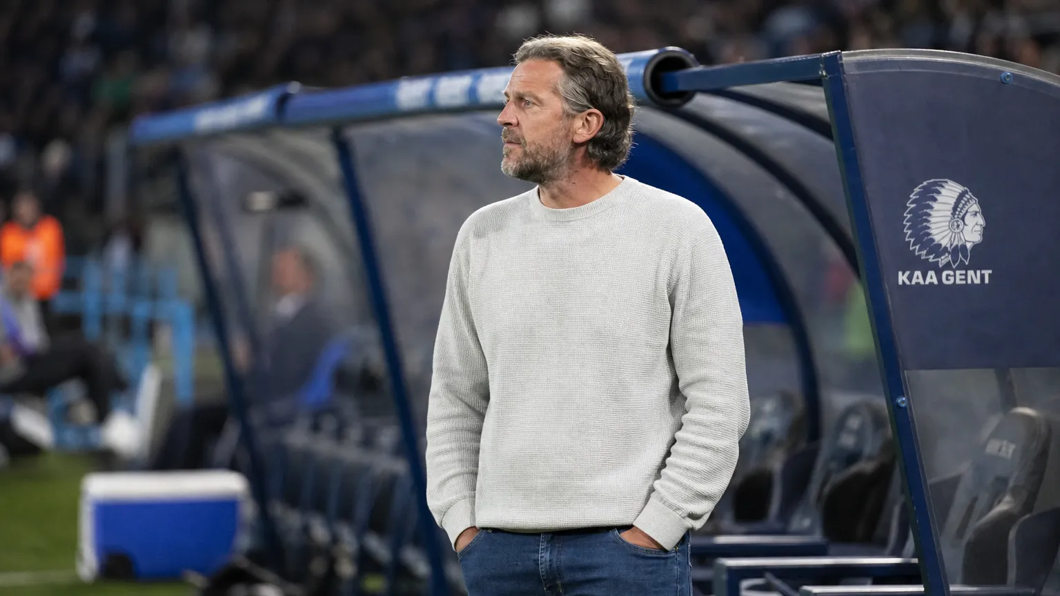 Rik De Mil staat na de wedstrijd bij de technische zone met een KAA Gent-embleem op de bezoekersbank.