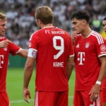 Een groep spelers van Bayern München overlegt op het veld tijdens een Bundesliga-wedstrijd.