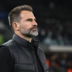 Ivan Leko in donkere coachkleding langs het veld na een wedstrijd.