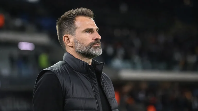Ivan Leko in donkere coachkleding langs het veld na een wedstrijd.