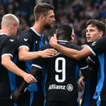 Een groep spelers van Club Brugge viert samen op het veld.