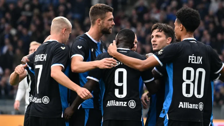 Een groep spelers van Club Brugge viert samen op het veld.
