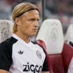 Kasper Dolberg in Ajax-tenue op de bank tijdens een competitiewedstrijd.
