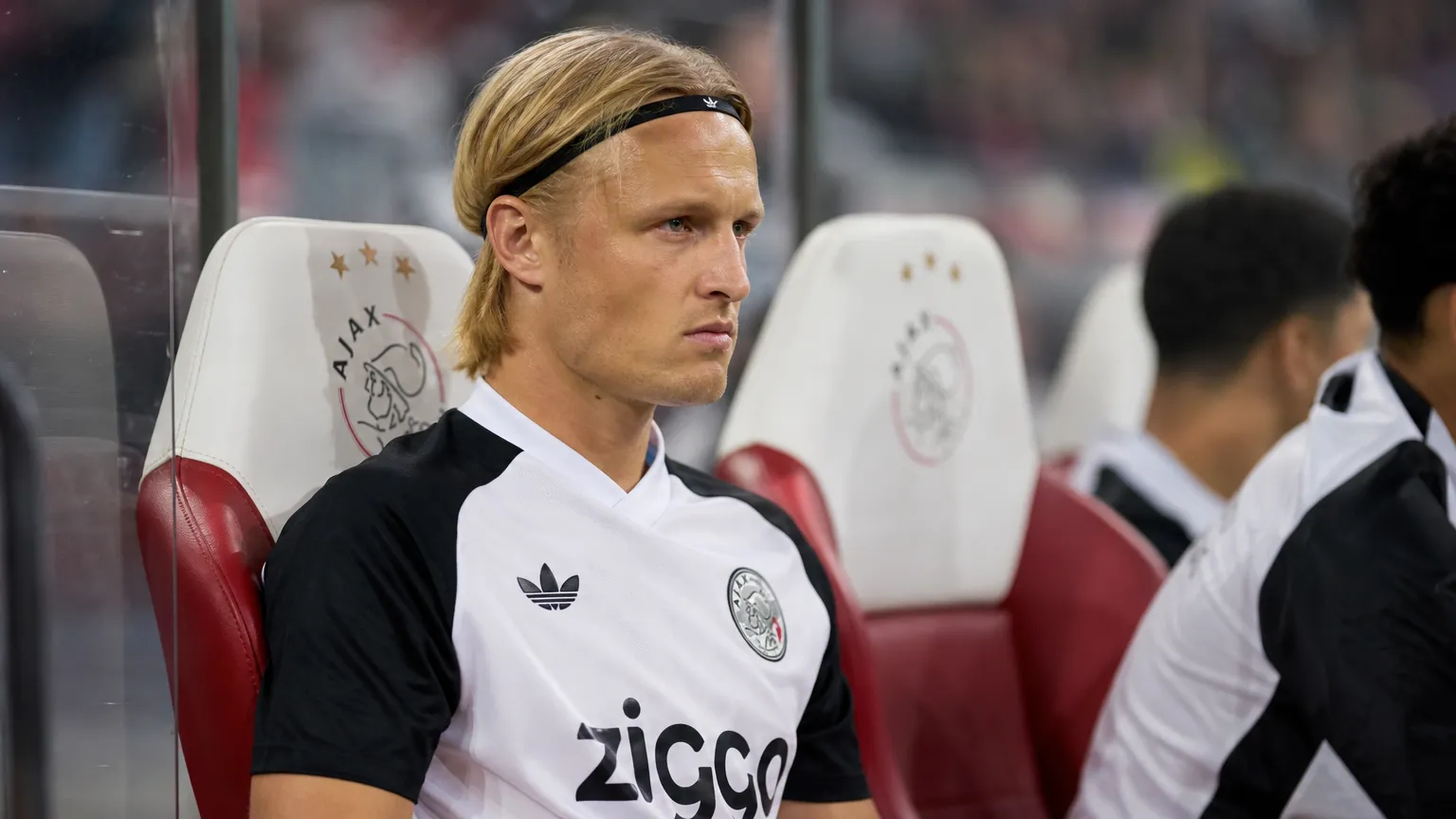 Kasper Dolberg in Ajax-tenue op de bank tijdens een competitiewedstrijd.