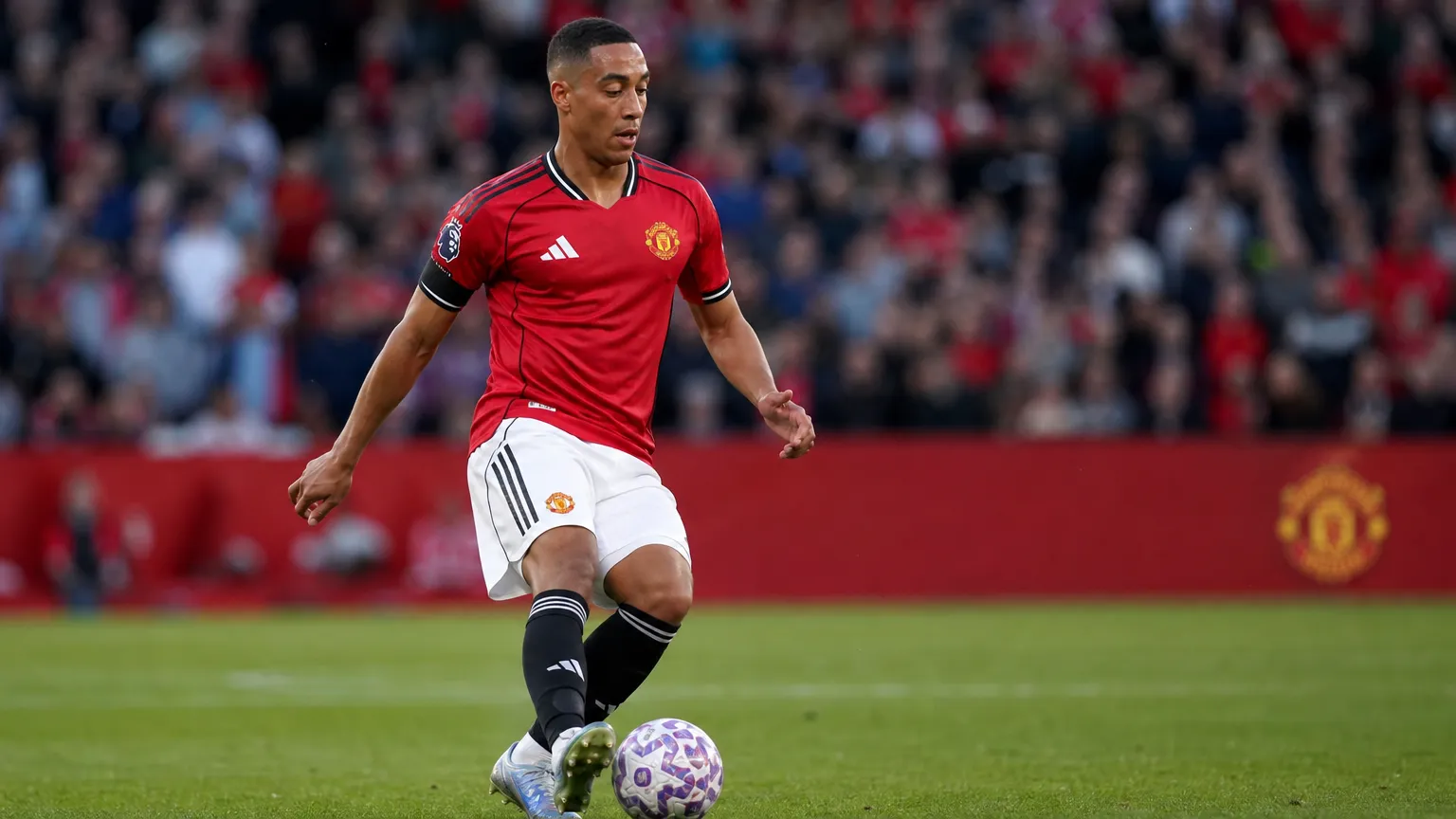 Youri Tielemans controleert de bal in het rode shirt van Manchester United.