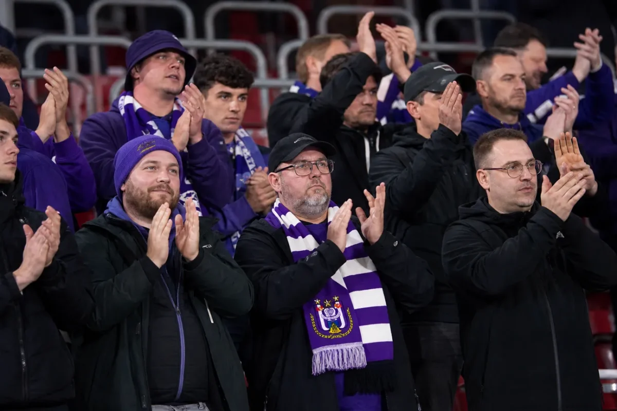 Een compacte groep Anderlecht-supporters in het uitvak met paars-witte sjaals.