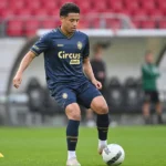 Anthony Valencia in donkerblauw Antwerp-shirt tijdens een opwarming op het veld.