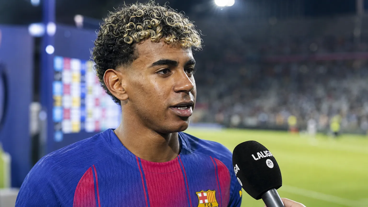 Lamine Yamal in het shirt van FC Barcelona tijdens een televisie-interview naast het veld.