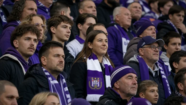 Een groep Anderlecht-supporters op de tribune met een paars-witte clubsjaal.