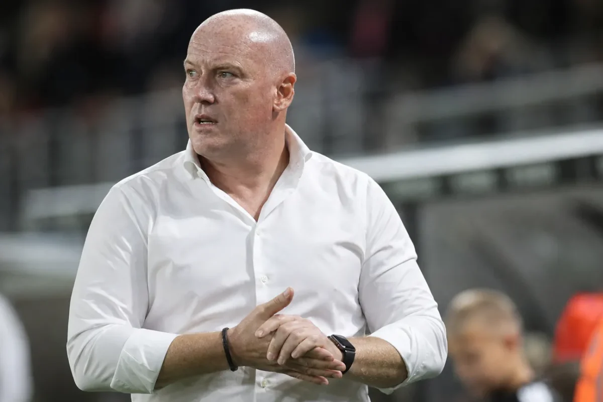 Een staflid van KV Mechelen staat na de wedstrijd op de zijlijn.