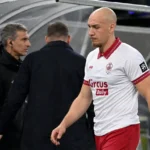 Michael Frey wandelt in zijn wit-rode Antwerp-tenue langs de bezoekersdug-out.