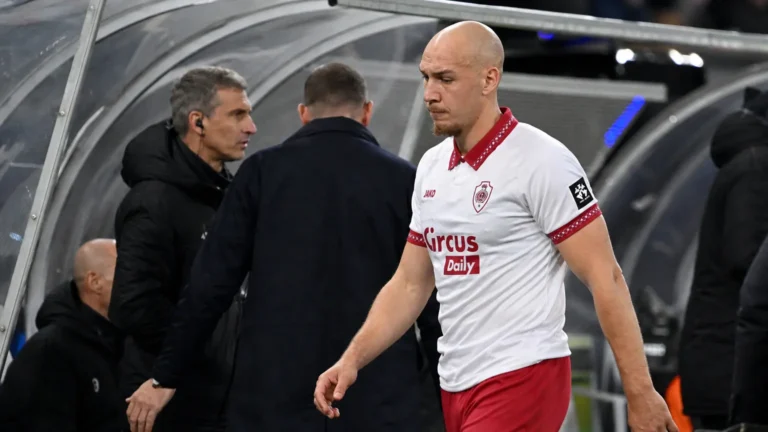 Michael Frey wandelt in zijn wit-rode Antwerp-tenue langs de bezoekersdug-out.