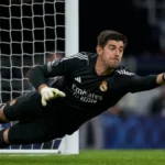 Thibaut Courtois duikt naar een bal tijdens een wedstrijd van Real Madrid.