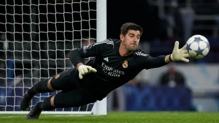 Thibaut Courtois duikt naar een bal tijdens een wedstrijd van Real Madrid.