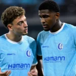 Twee voetballers bespreken de wedstrijd na afloop op het veld.