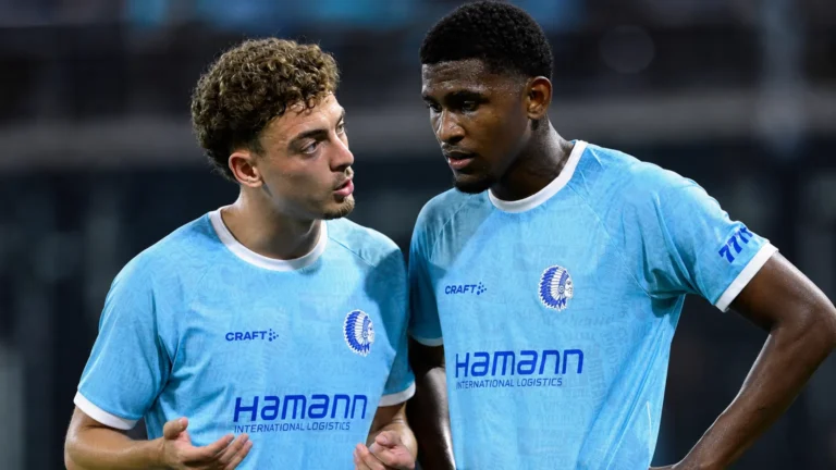Twee voetballers bespreken de wedstrijd na afloop op het veld.
